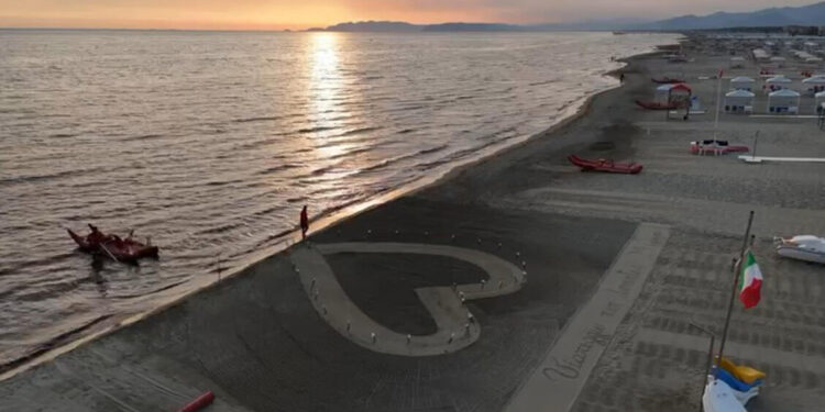 Un grande cuore sulla sabbia e 32 fiori in ricordo delle vittime della strage di Viareggio